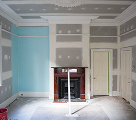 Replastered room with ceiling rose and large cornice, skirtings and picture rail ready for paint