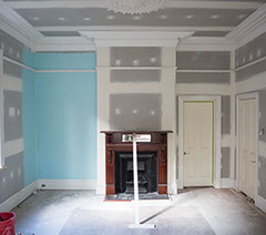 Replastered room with ceiling rose and large cornice, skirtings and picture rail ready for paint