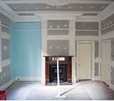 Replastered room with ceiling rose and large cornice, skirtings and picture rail ready for paint